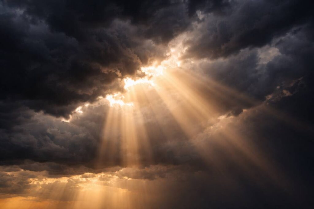 Storm clouds with light breaking through representing faith during hardship.